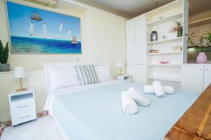 una camera da letto bianca con un letto bianco con cuscini bianchi di Endless Blue Studio in Glyfada ad Atene