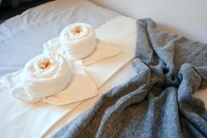 zwei Rollen weiße Handtücher auf einem Bett in der Unterkunft ERH01-RI Flat in Herzogenaurach in Herzogenaurach