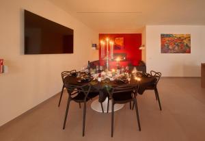 a dining room with a table and chairs with lights at Garden e Wellness LE VIGNE - relax e luxus in Tesimo