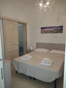 a bedroom with a bed with two towels on it at Sal y Mar in Torre San Giovanni Ugento