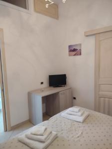 Pokój z biurkiem i 2 ręcznikami na łóżku w obiekcie Sal y Mar w mieście Torre San Giovanni Ugento