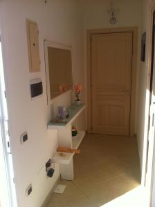 łazienka z umywalką, lustrem i drzwiami w obiekcie Sal y Mar w mieście Torre San Giovanni Ugento
