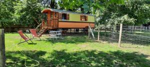 a small house in a yard with a playground at CHARLOTTE LA ROULOTTE in Grosbreuil