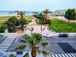 Blick auf einen Parkplatz mit Palmen und den Strand in der Unterkunft Arrecife Beach in La Pineda