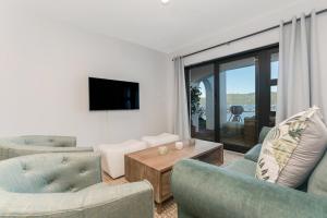 a living room with two chairs and a tv at Vista Laguna in Knysna
