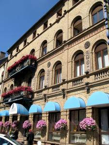 a large brick building with flowers in the windows at Hôtel EUROPE in Saverne