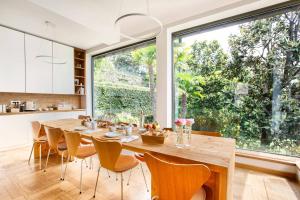 una cucina e una sala da pranzo con tavolo e sedie in legno di Villa Noseda a Moltrasio