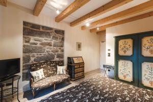 a living room with a couch and a stone wall at Hotel Savoia dal 1924 in San Martino di Castrozza