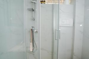una doccia con porta in vetro in bagno di Endless Blue Studio in Glyfada ad Atene