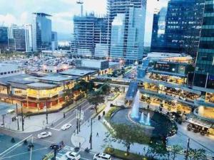 an aerial view of a city with a fountain at Cozy 1 BR One Uptown Residences BGC in Manila