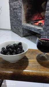 una ciotola di more accanto a un bicchiere di vino di Friendly House a Akhaltsikhe