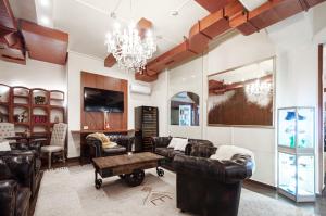 a living room with leather furniture and a chandelier at Acquarello Swiss Quality Hotel in Lugano