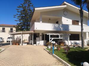 a white house with a driveway in front of it at Azzurro mare in Arenella