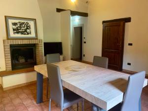 comedor con mesa, sillas y chimenea en Caratteristico appartamento nel borgo medievale en Castiglione della Pescaia