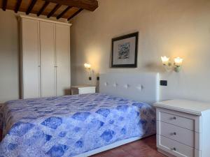 1 dormitorio con 1 cama con edredón azul en Caratteristico appartamento nel borgo medievale en Castiglione della Pescaia