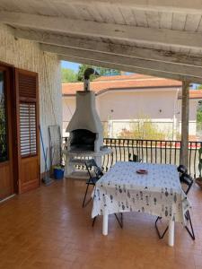 patio con mesa y horno al aire libre en Villa Flore - Penthouse - apartment in villa, en Casteldaccia