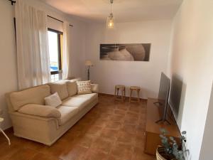 sala de estar con sofá y TV en V V El Cantil, en Valverde