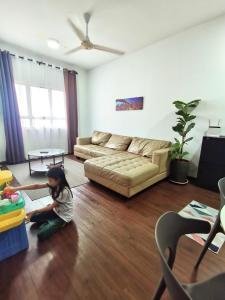 una niñita sentada en el suelo en una sala de estar en Apartment in Ladang Tok Pelam - Hana Home by the Sea, en Kuala Terengganu