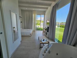 ein Hotelzimmer mit einer Badewanne und einem Schlafzimmer in der Unterkunft Luxury Pool Suites - Città Bianca in Pescara