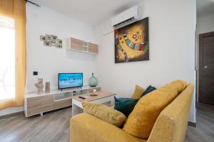 een woonkamer met een bank en een tv bij Cambrils Turistic Atico in Cambrils