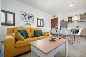 een woonkamer met een gele bank en een keuken bij Cambrils Turistic Atico in Cambrils