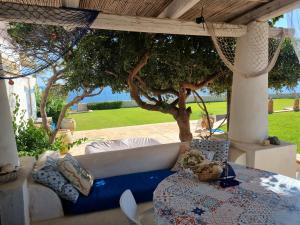 a living room with a couch and a tree at Villa Sicily Sul Mare Tra Catania e Siracusa in Augusta