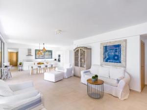 a living room with white furniture and a kitchen at Dilean luxury villa in Vourvourou