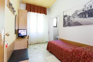 a bedroom with a bed and a television in it at Hotel Al Mare in Lido di Jesolo