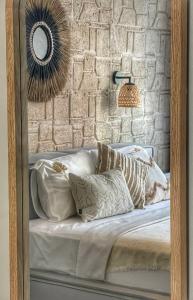 uma cama com almofadas e um espelho na parede em alba otel em Ildır