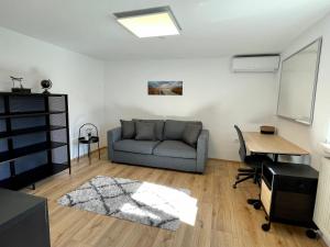 a living room with a couch and a table at sHome TinyHouse Feldkirchen bei Graz - Self-Check-in in Feldkirchen bei Graz