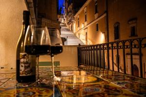 eine Flasche Wein auf einem Tisch mit einem Glas in der Unterkunft Scala 70° Attico Esclusivo in Caltagirone