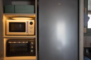 eine Küche mit einer Mikrowelle und einem Backofen in der Unterkunft Scala 70° Attico Esclusivo in Caltagirone