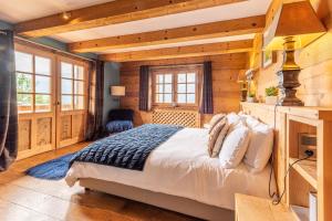 a bedroom with a bed in a room with wooden walls at Chalet Victoria - Magnifique chalet avec piscine privée in Saint-Gervais-les-Bains