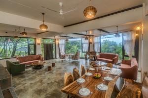 a living room with a table and chairs at SaffronStays Aranya Vilas & Raanwaara Cottage in Āmbavna
