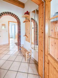 a hallway with a chair and an archway at Am Sommerdeich in Norden