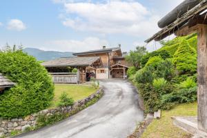 a driveway leading to a house with a stone wall at Chalet Victoria - Magnifique chalet avec piscine privée in Saint-Gervais-les-Bains