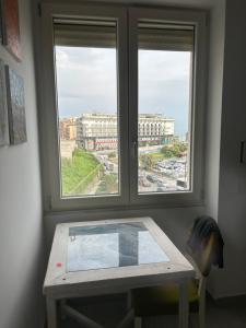 - une table dans une chambre avec 2 fenêtres dans l'établissement ViVa House Salerno, à Salerne