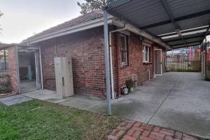 a brick house with an open door and a garage at Comfortable 3 bebrooms old home with parking in Sunshine