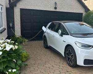 a white car parked in front of a garage at Cosy Cabin, hidden from the main house - Sleeps 2 - EV in Hawkinge