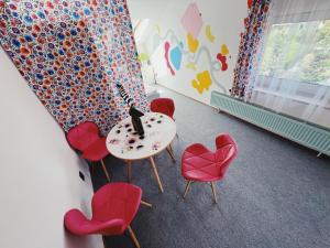 a room with red chairs and a table with a cat on it at Tartaczna 9 in Wisła