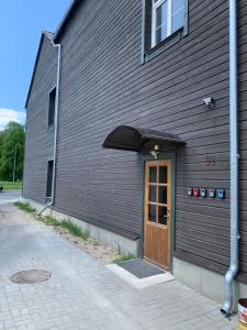 ein Gebäude mit einer Holztür und einem Fenster in der Unterkunft Delta 10- two big beds in Tartu