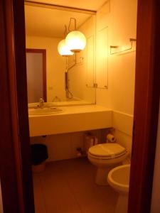 a bathroom with a sink and a toilet and a mirror at Appartamento 109 - Multiproprietà I Boboli BC in Punta Ala