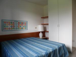 a bedroom with a bed with a blue blanket at Appartamento 109 - Multiproprietà I Boboli BC in Punta Ala