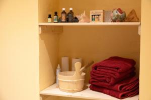 - une étagère avec une serviette rouge et des bouteilles dans l'établissement Moderne Ferienwohnungen in alter Villa, à Georgenthal