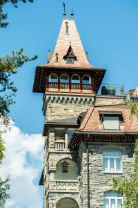 um edifício alto com uma torre com um telhado em Edelweiss Schlosswohnung em Flims