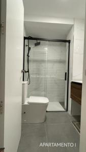 a bathroom with a glass shower with a toilet at Urbanlux Belmonte Suite in Albacete