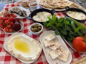 a table with plates of food on a red and white table cloth at Beit Mirna Guesthouse & Chalet - Ehden in Ehden