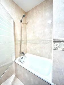 uma casa de banho com uma banheira branca e um chuveiro em Hispalis Mazagón Beach 303 em Mazagón