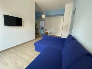 een woonkamer met een blauwe bank en een tv bij B&B Syrentum in Sorrento