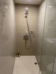 baño con ducha y puerta de cristal en Modern & Sleek 1 BR Uptown Parksuites, en Manila